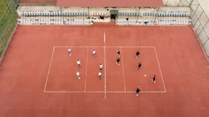 Un grupo de personas de pie encima de una cancha de tenis