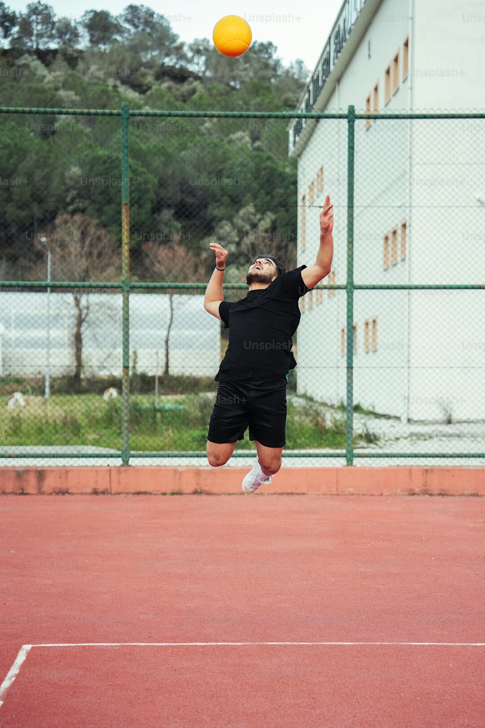 a man jumping in the air to hit a tennis ball