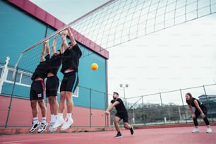 Un grupo de jóvenes jugando un partido de tenis