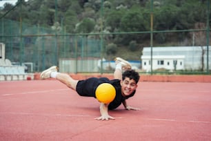 a man laying on the ground with a yellow ball