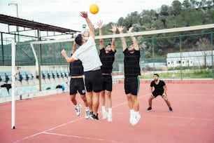 Eine Gruppe junger Männer spielt eine Partie Volleyball
