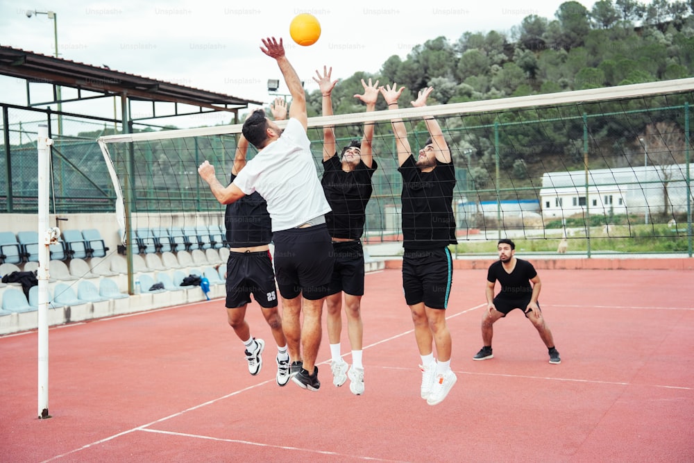 a group of young men playing a game of volleyball