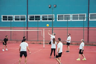a group of people playing tennis on a court