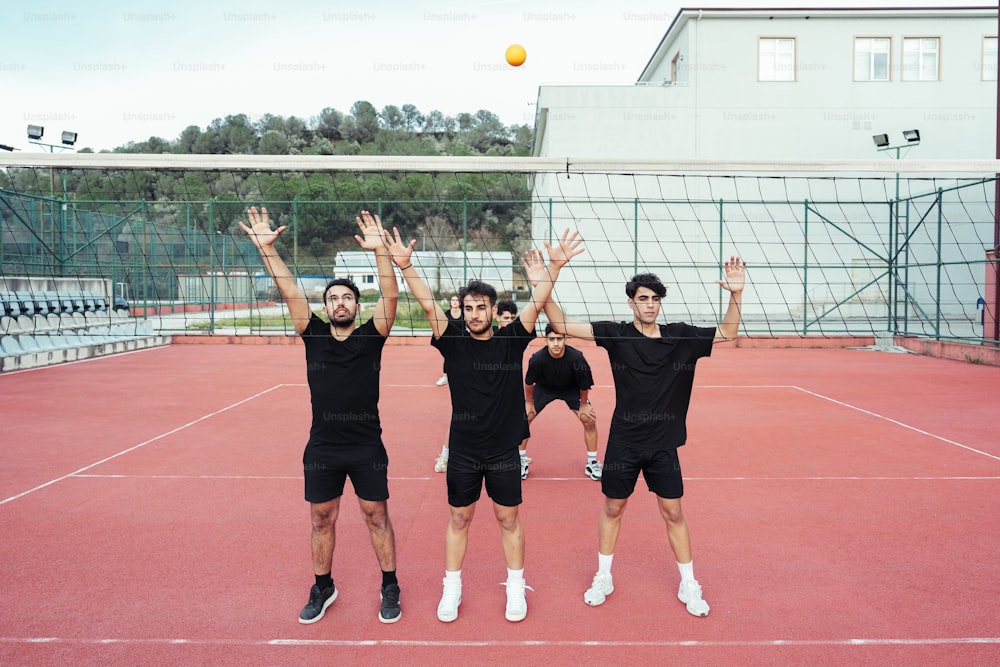 un gruppo di uomini in piedi in cima a un campo da tennis