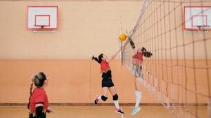 a group of young girls playing a game of volleyball