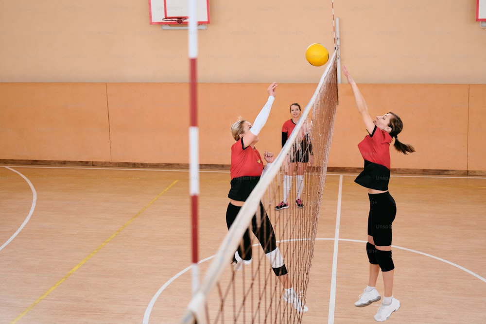 a group of young women playing a game of volleyball