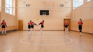 a group of young women playing a game of volleyball