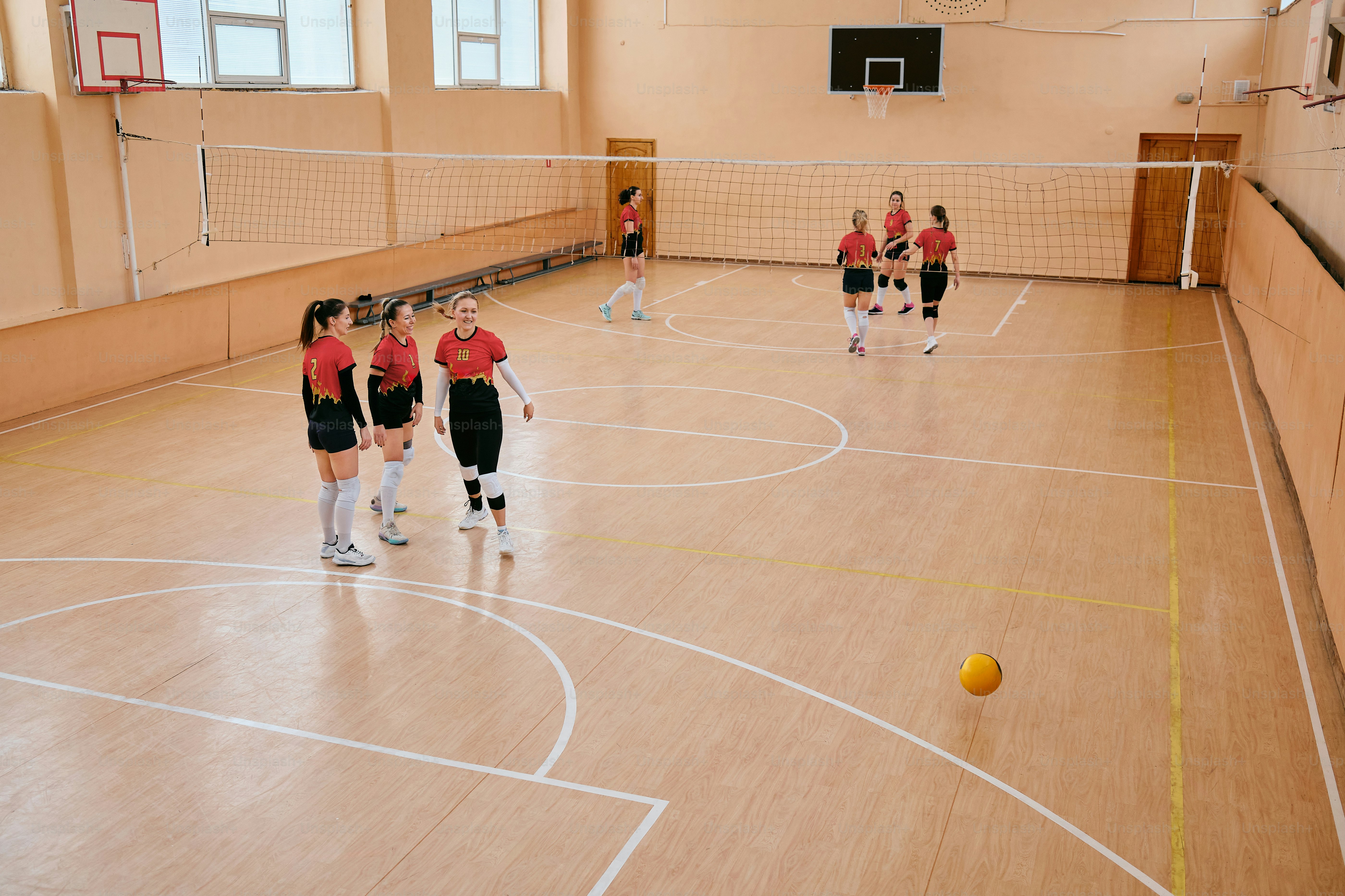 a group of girls playing a game of volleyball
