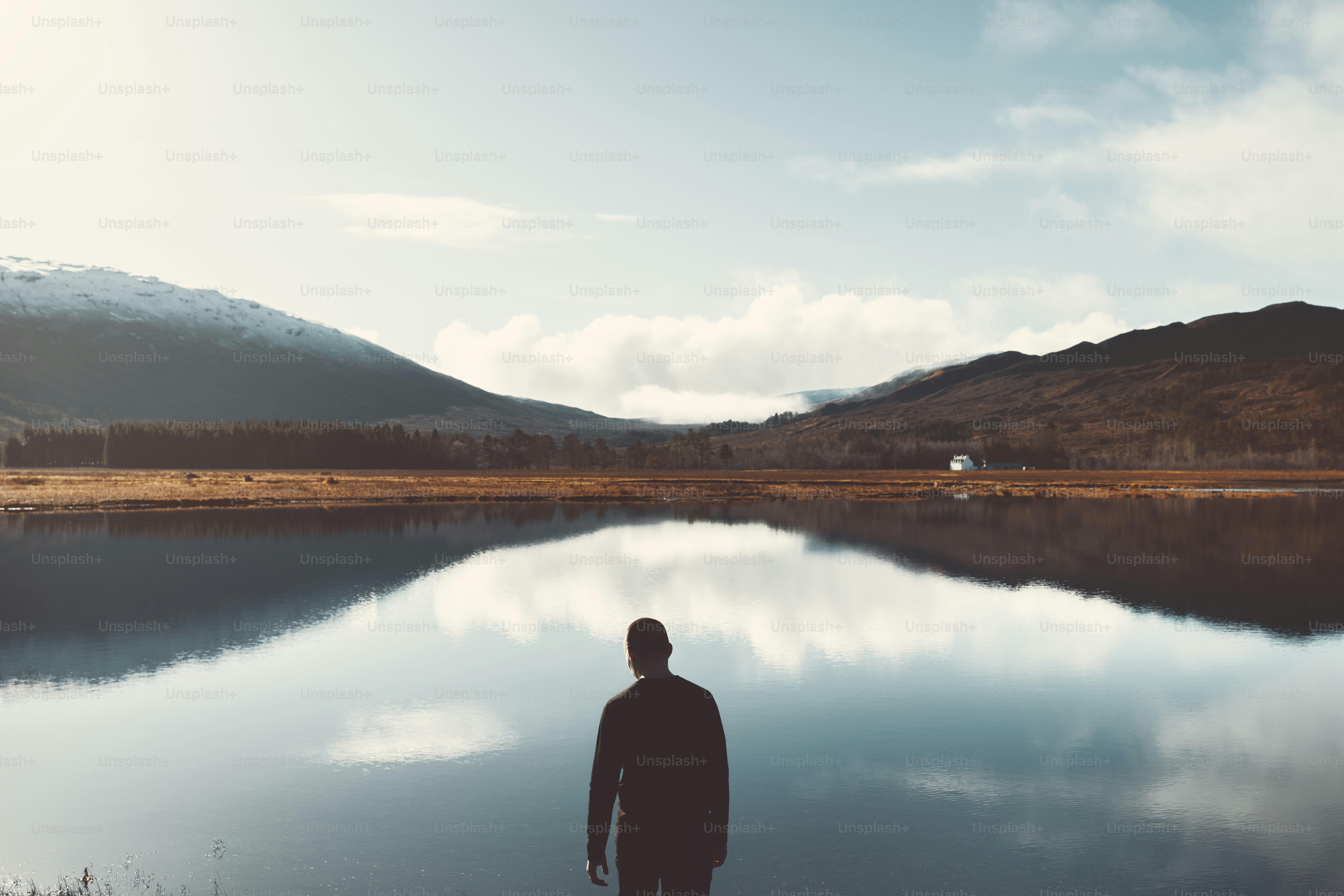 A man standing in front of a body of water photo – Lake Image on Unsplash