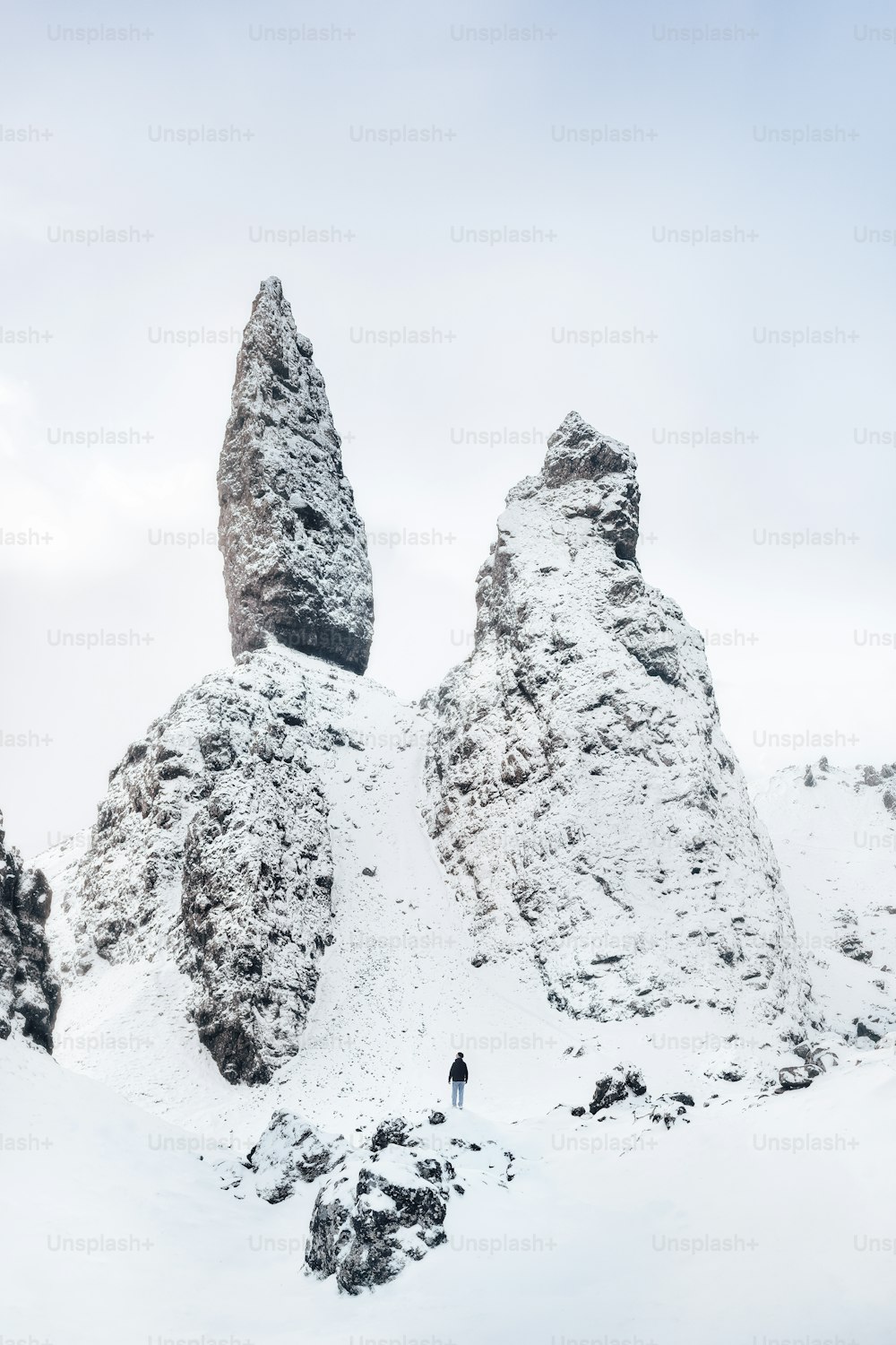 una persona in piedi sulla cima di una montagna innevata
