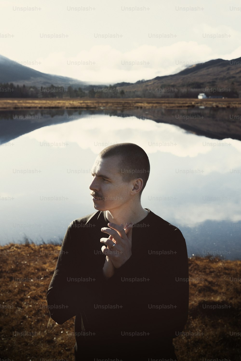 a man standing in front of a body of water