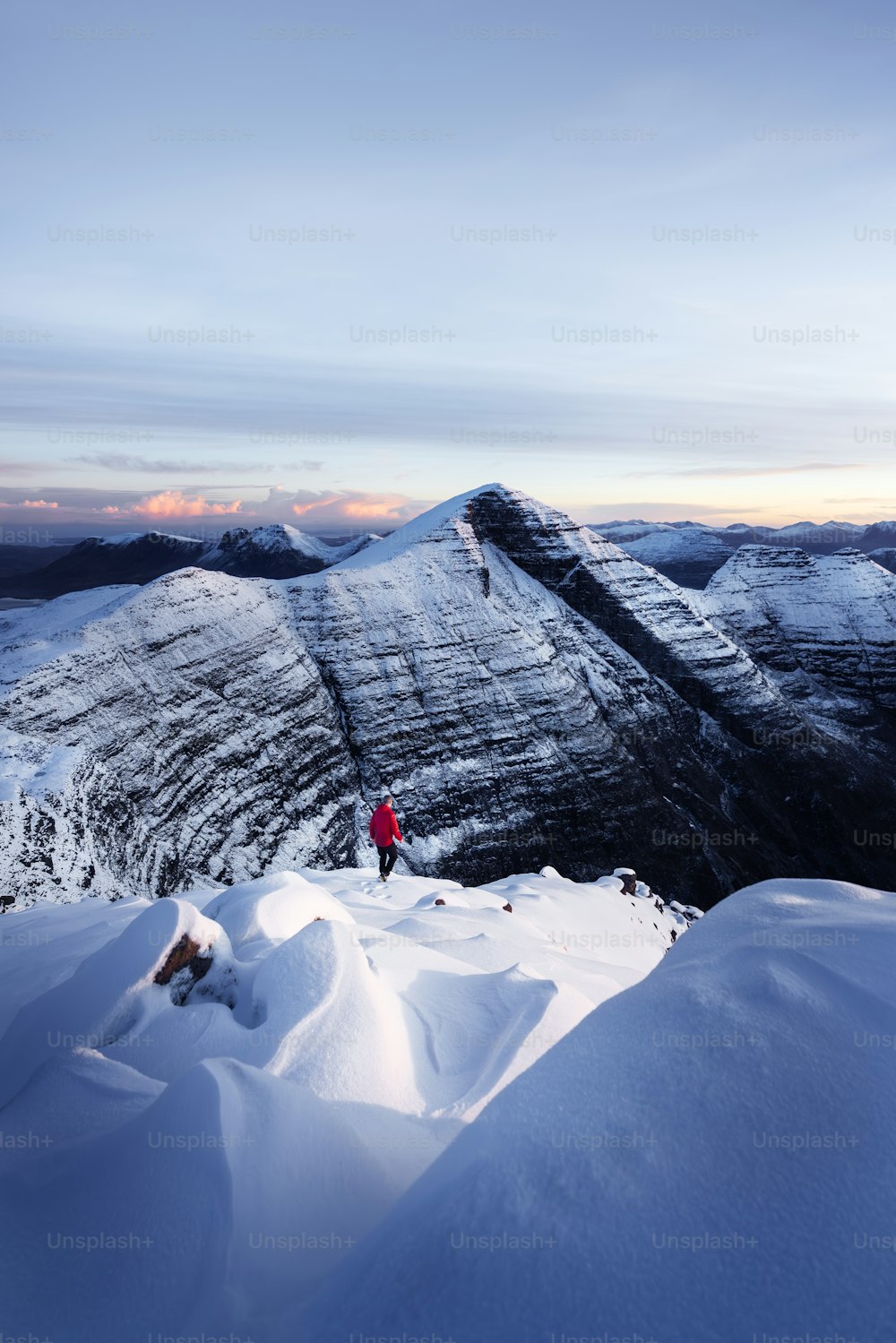 a person standing on top of a snow covered mountain
