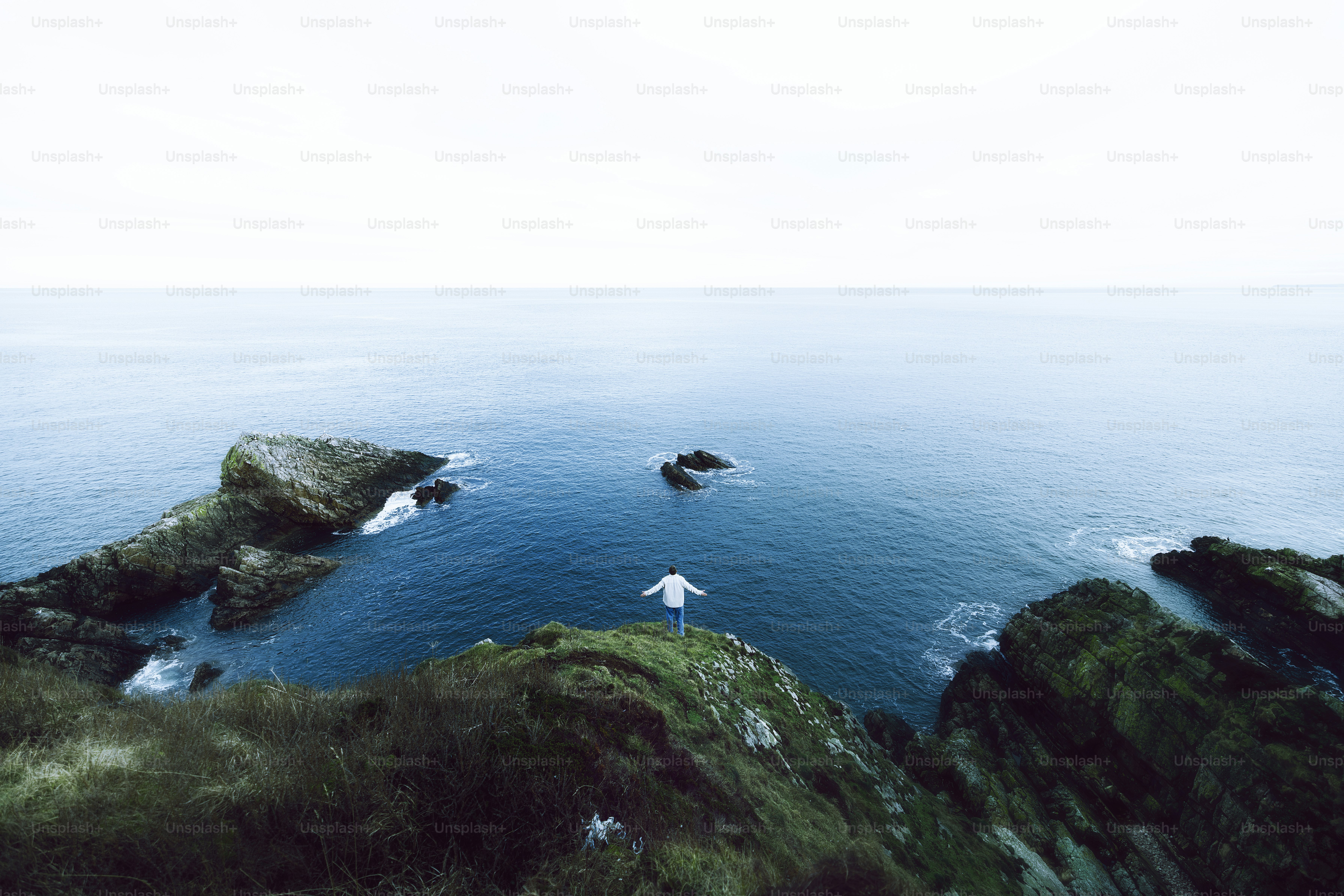 a couple of white birds flying over a body of water