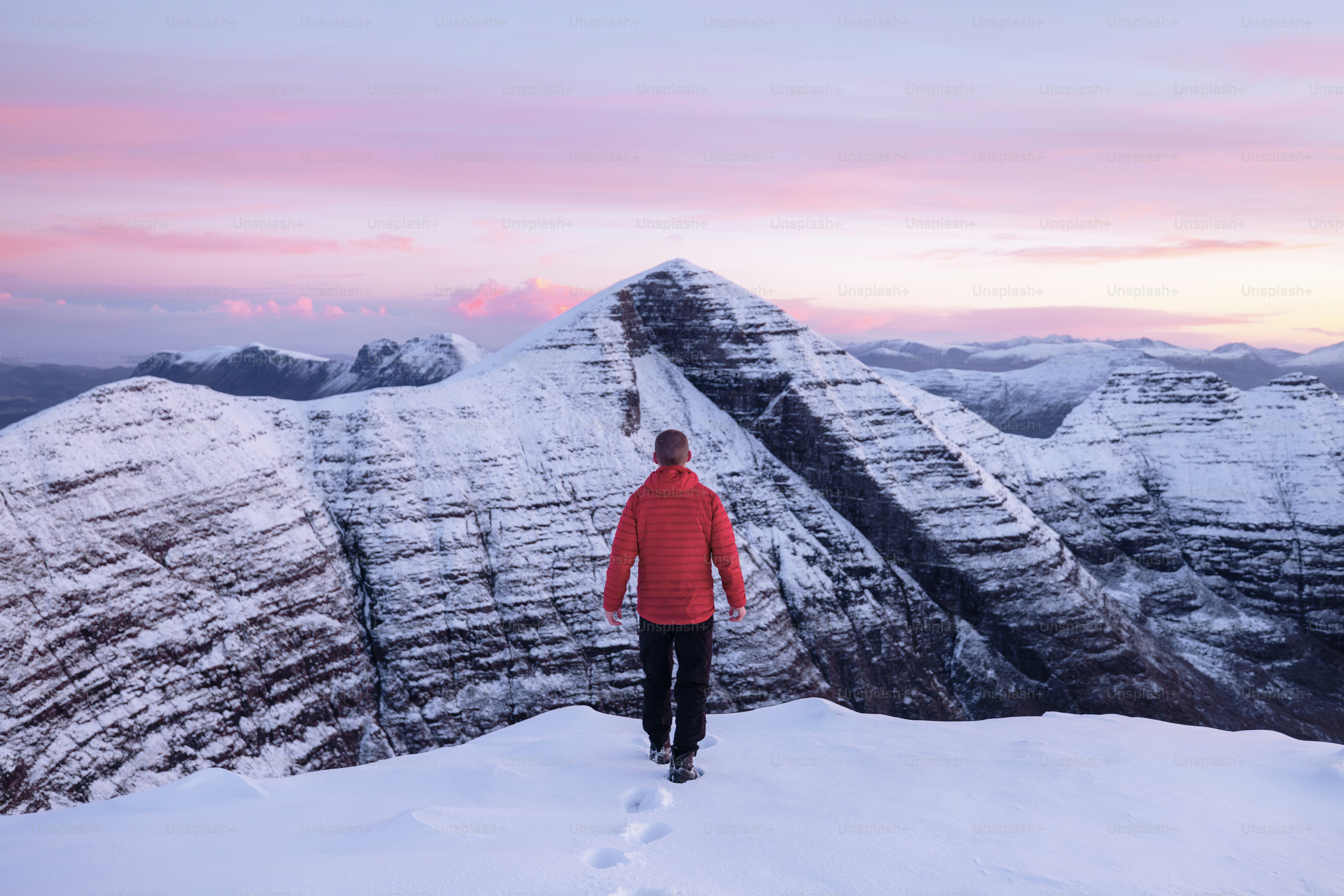 A man standing on top of a snow covered mountain photo – Winter scene ...
