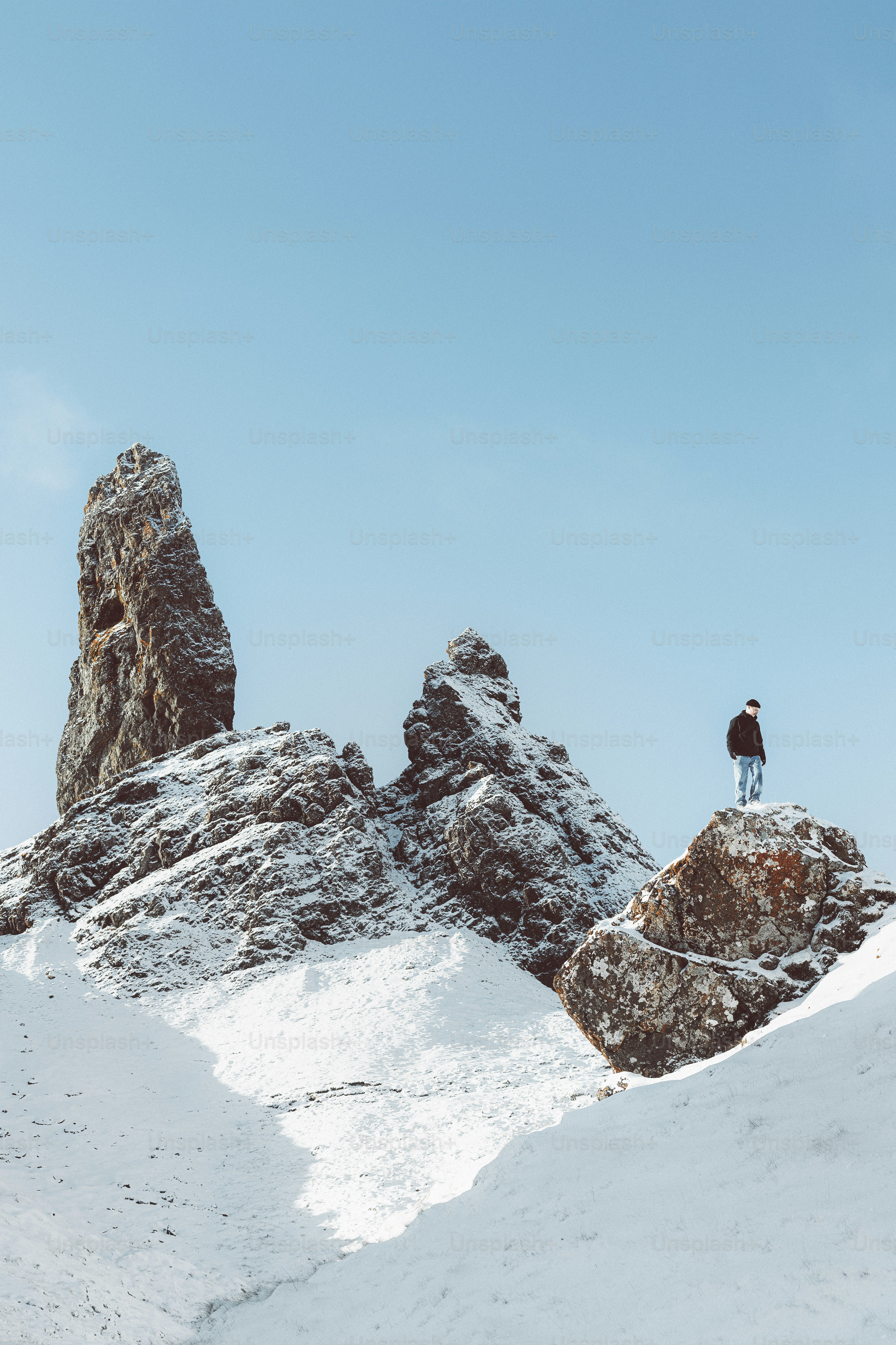 un uomo in piedi sulla cima di una montagna coperta di neve