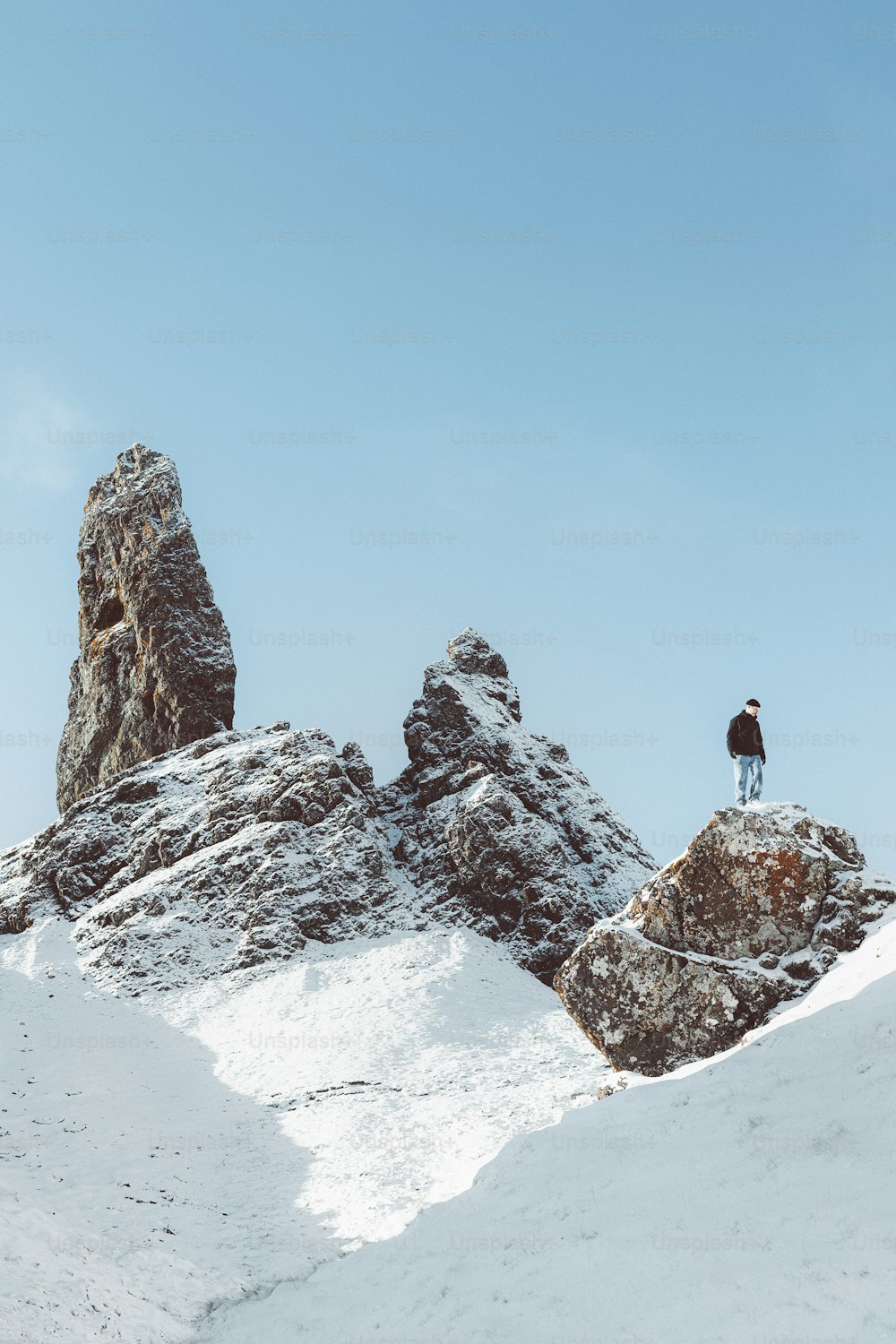un uomo in piedi sulla cima di una montagna coperta di neve