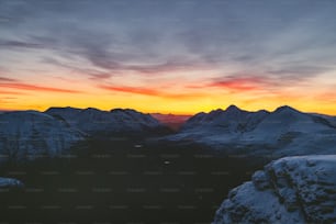 Blick auf eine Bergkette mit Sonnenuntergang im Hintergrund