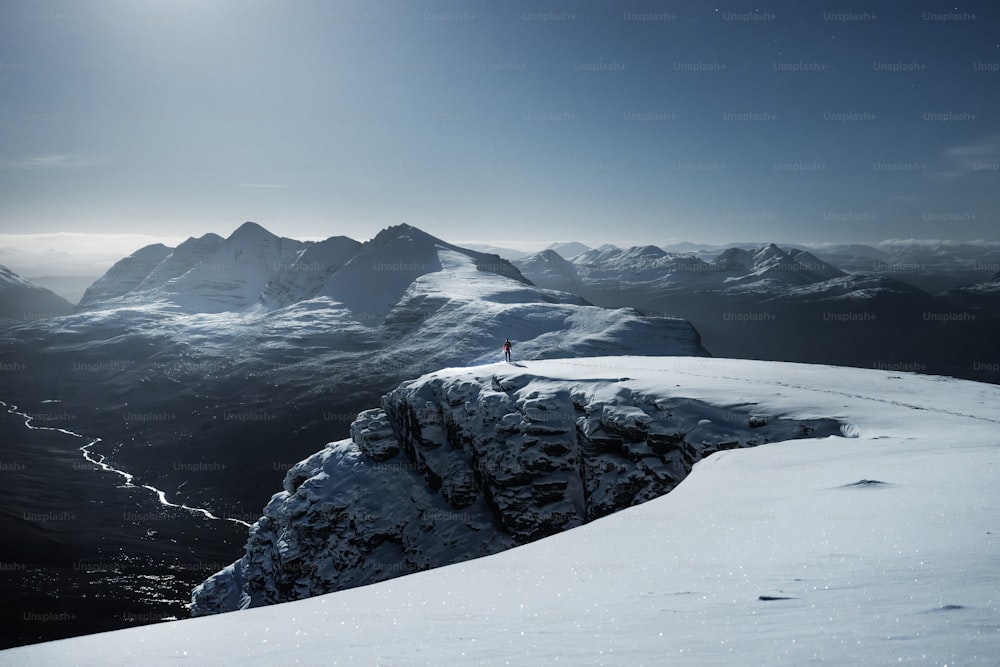 a person standing on top of a snow covered mountain