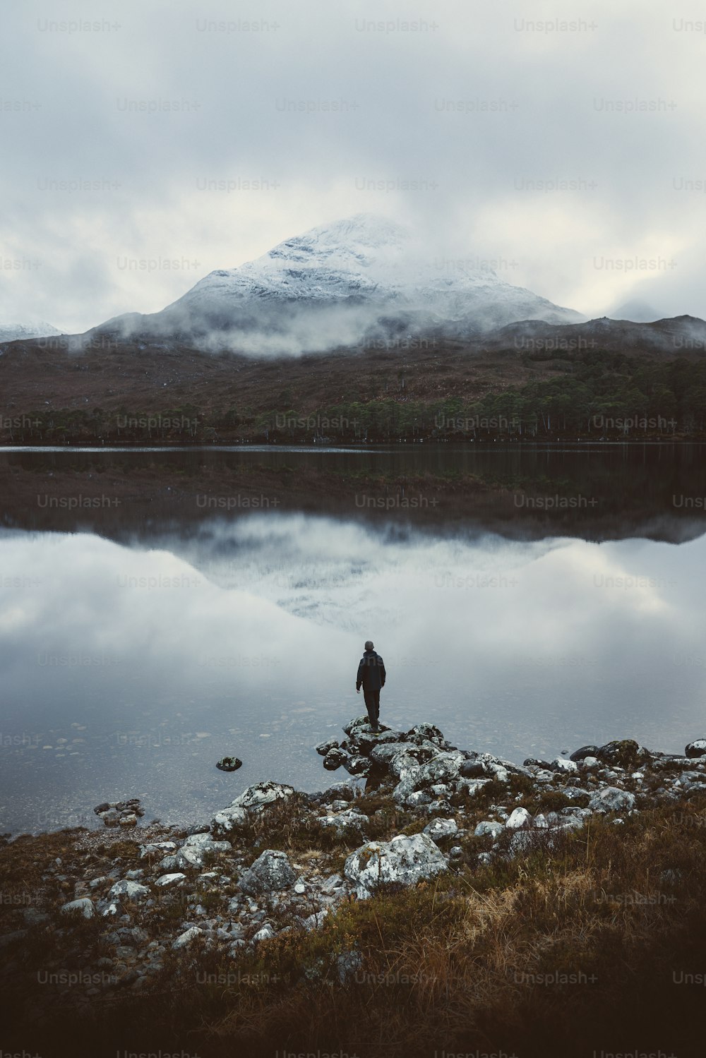 a person standing on a rock near a body of water