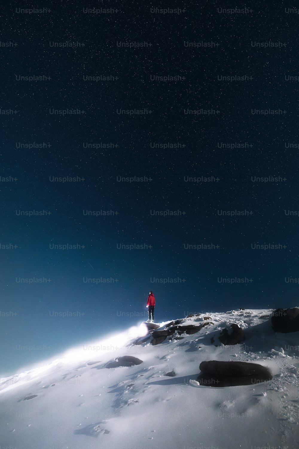 uma pessoa em pé no topo de uma colina coberta de neve