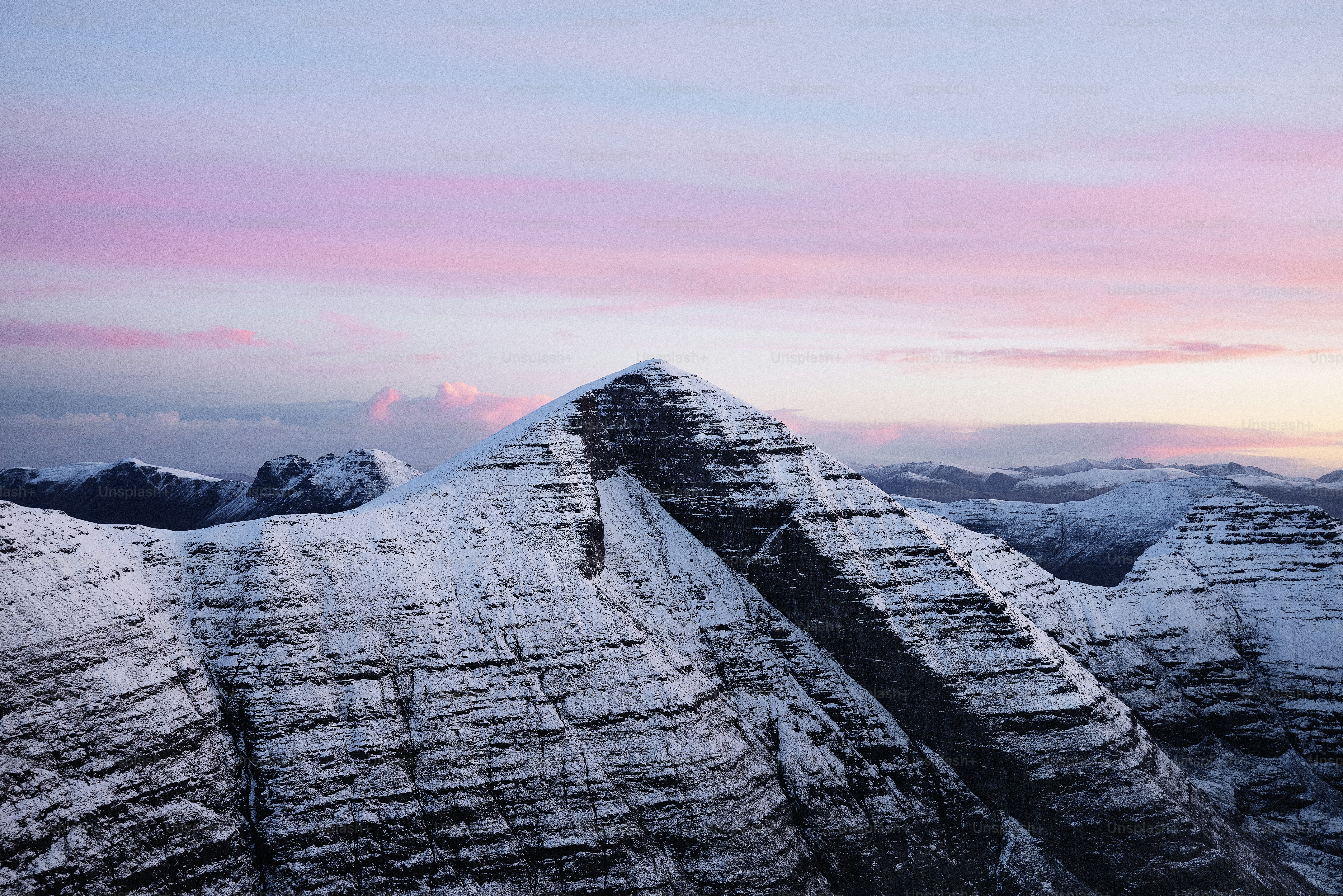 a snow covered mountain with a pink sky in the background