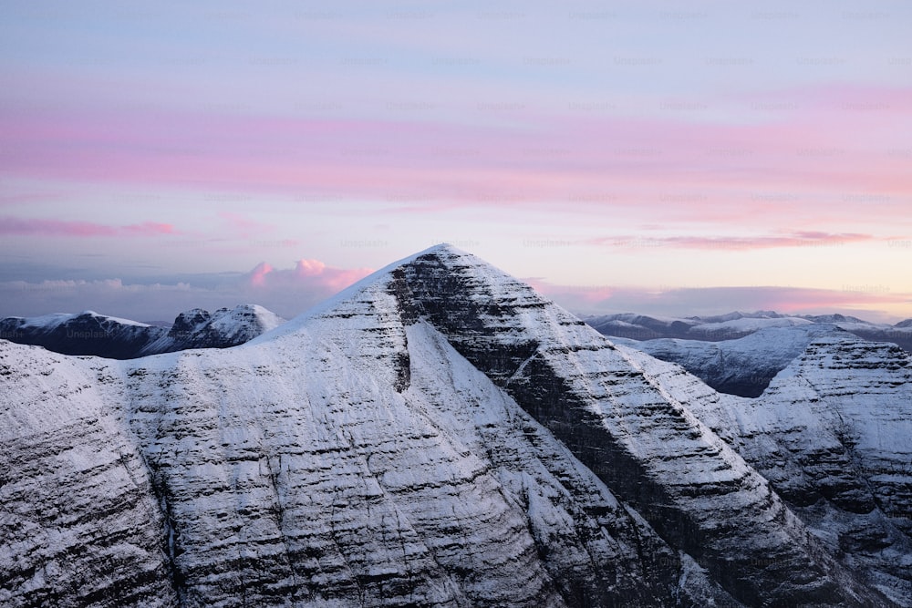 a snow covered mountain with a pink sky in the background