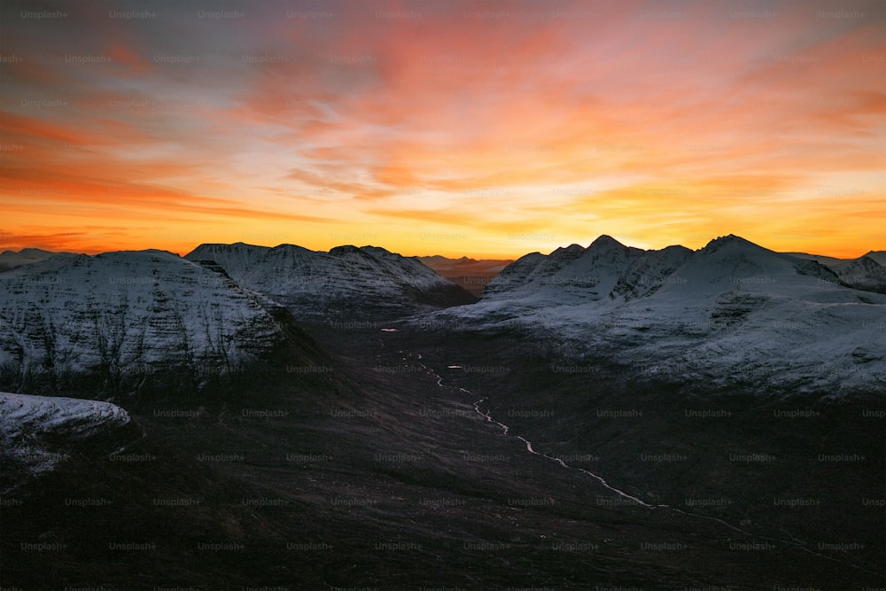 a view of a mountain range with a sunset in the background