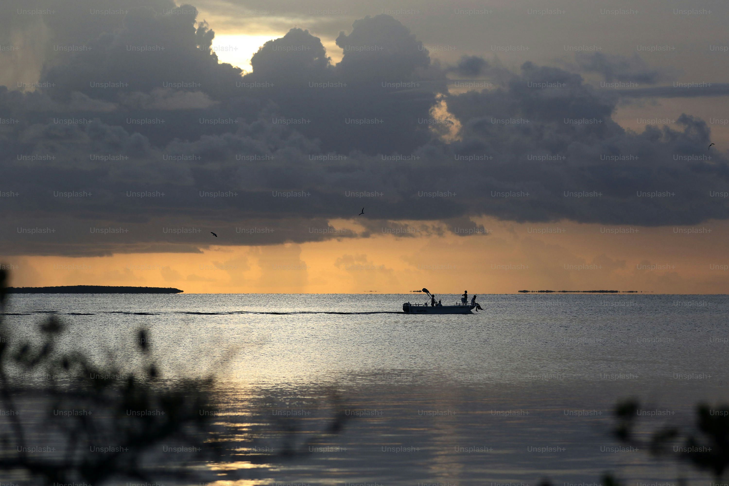 a boat is out on the water at sunset