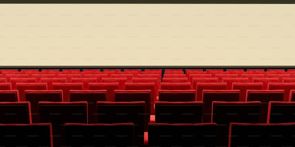 una hilera de sillas rojas frente a una pantalla blanca