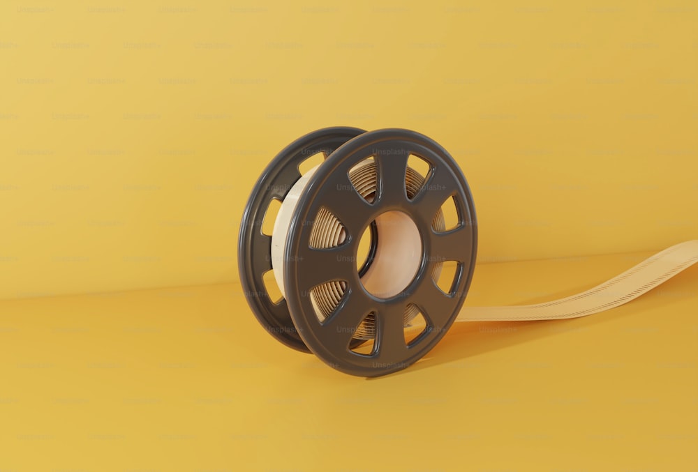 un moulinet avec une bobine de fil sur fond jaune