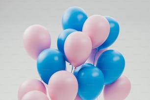 a bunch of blue and pink balloons floating in the air