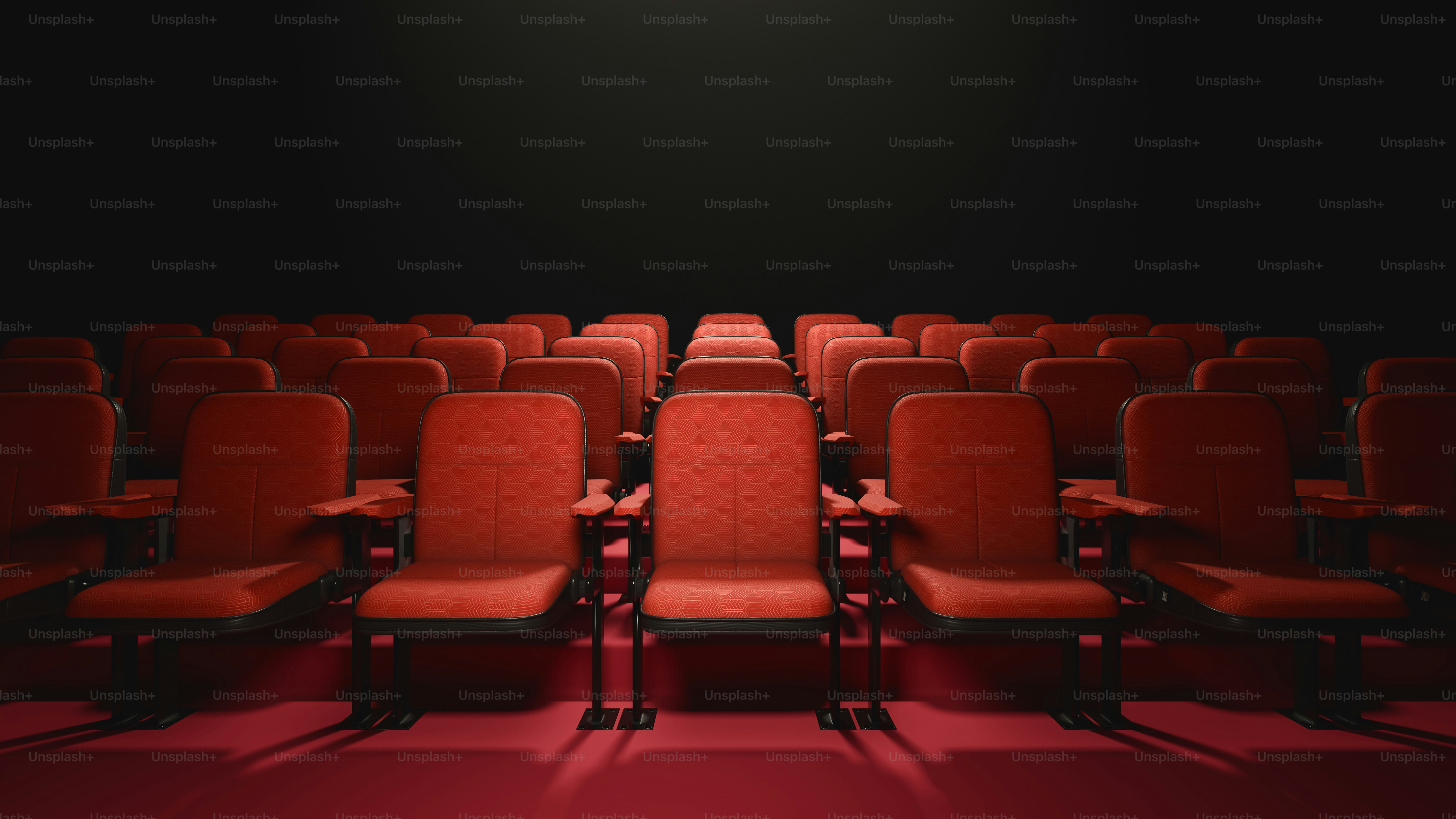 una hilera de sillas rojas sentadas frente a una pared negra