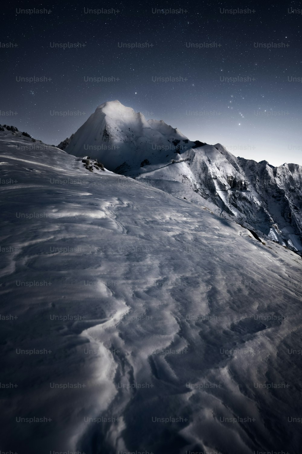 a mountain covered in snow under a night sky