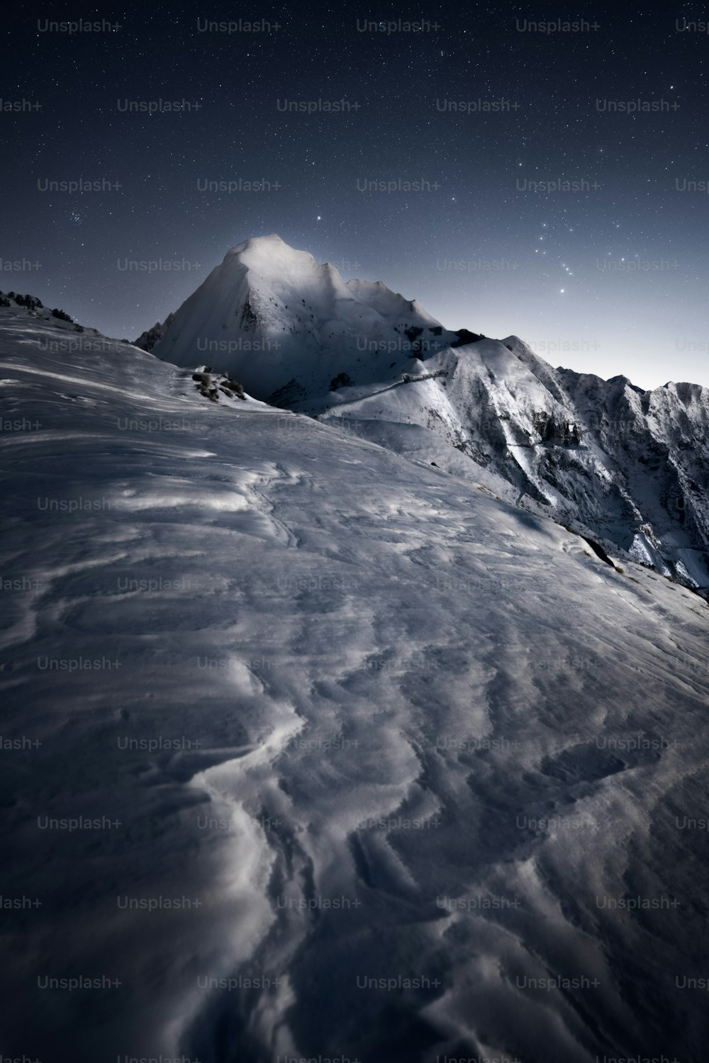 una montaña cubierta de nieve bajo un cielo nocturno