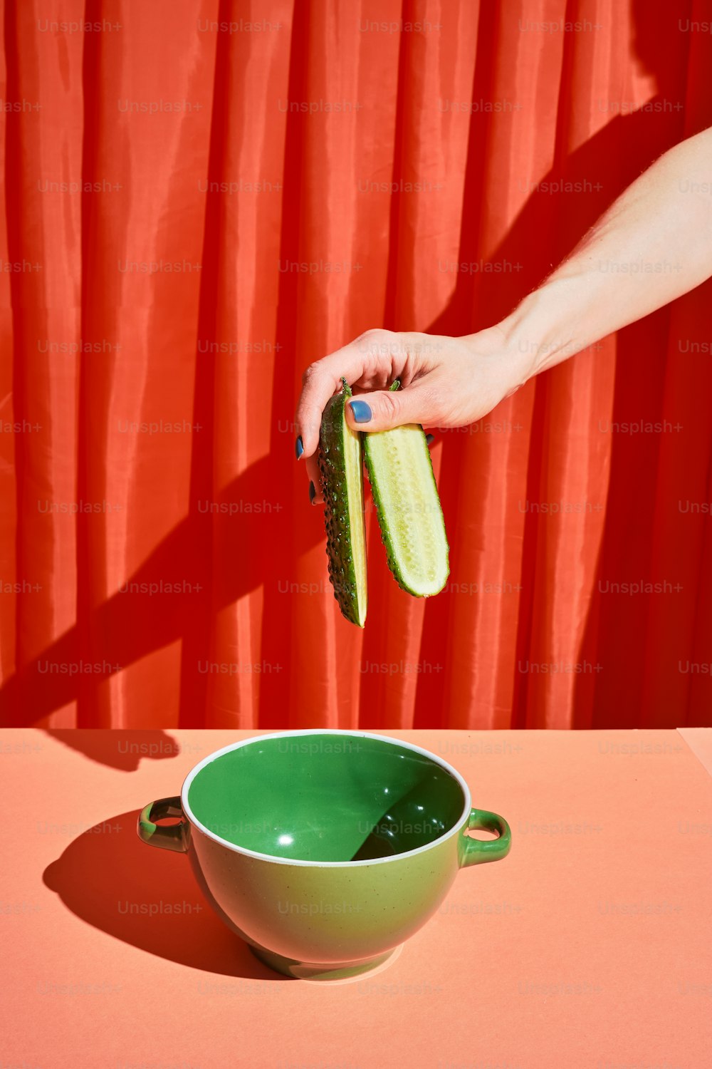 a woman's hand is cleaning a bowl with a green cloth