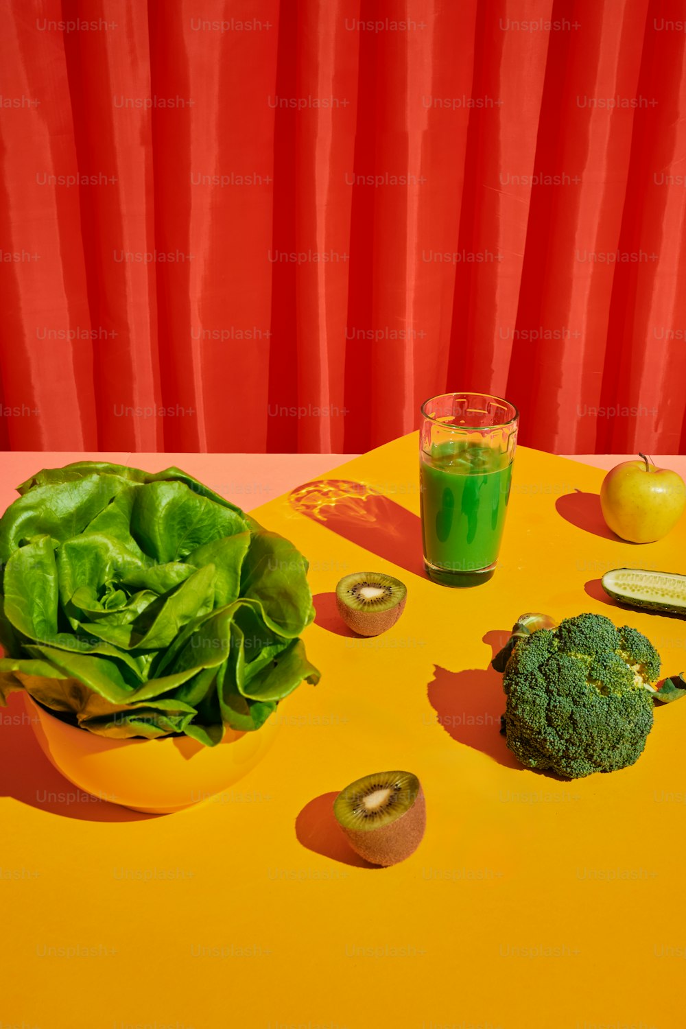 ein Tisch mit einer Schüssel Salat neben einem Glas Saft