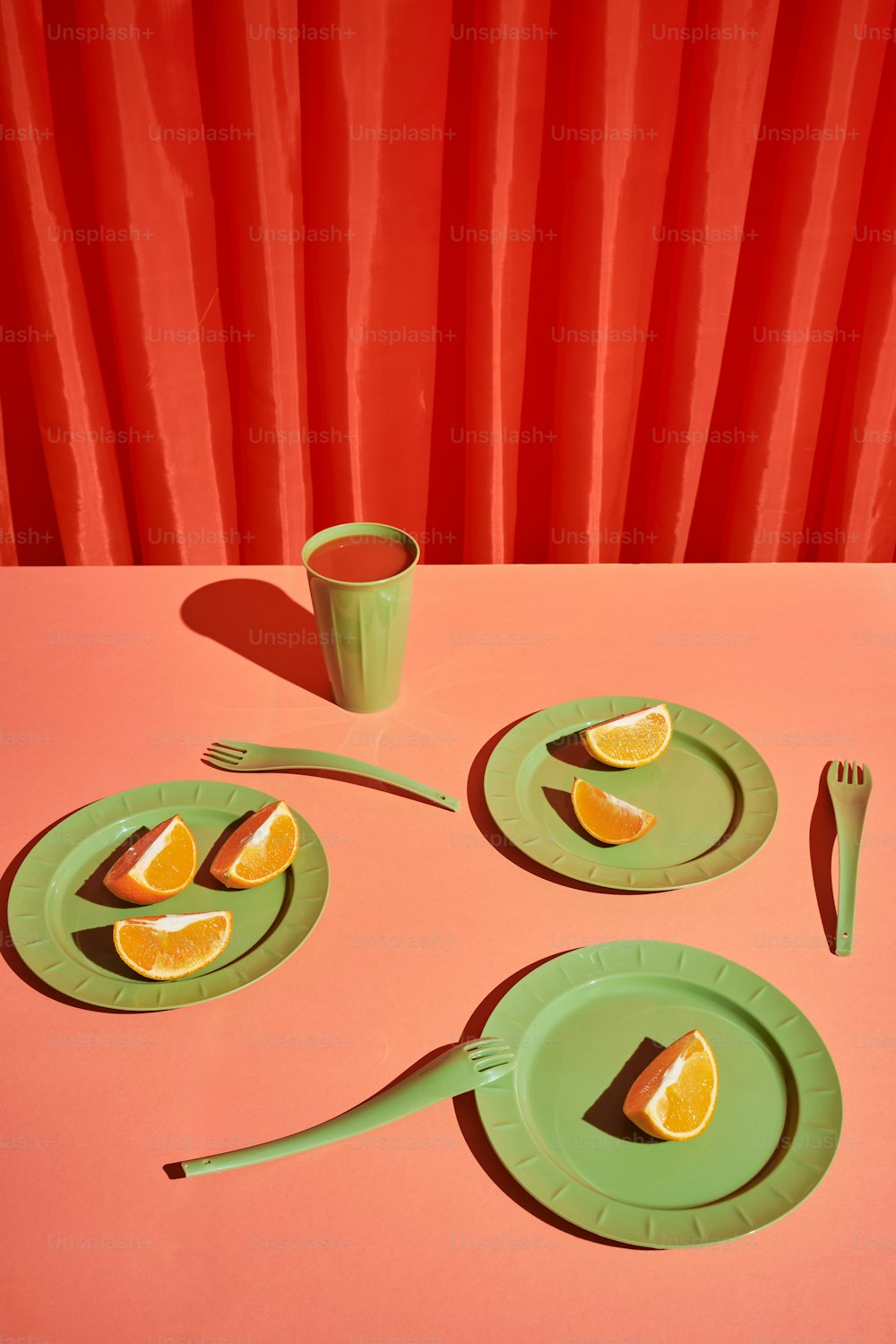 une table surmontée d’assiettes vertes recouvertes de tranches d’orange