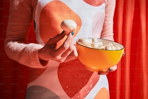 a woman holding a bowl of food and a spoon