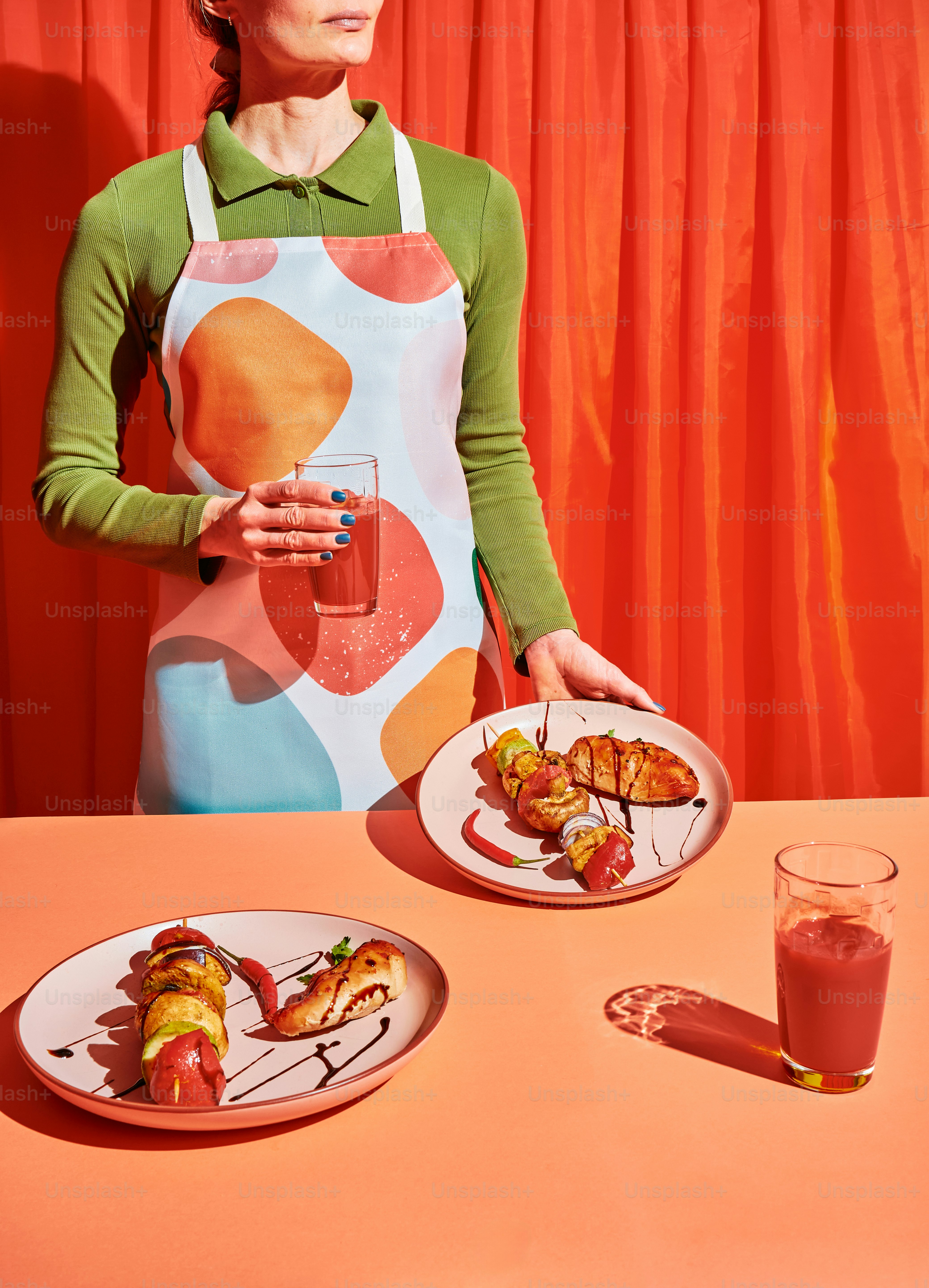 a woman in an apron holding a plate of food