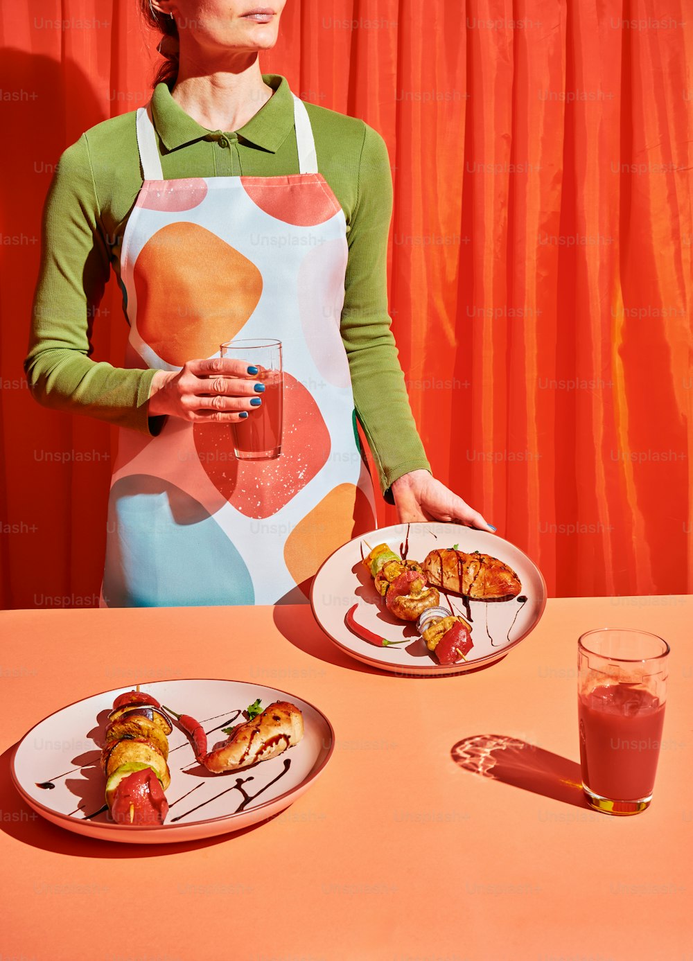 a woman in an apron holding a plate of food