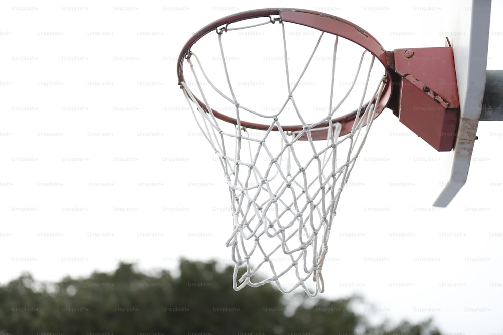 ein Basketball, der durch das Netz eines Basketballkorbs geht