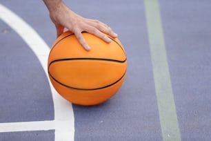 una persona che tiene un pallone da basket su un campo da basket
