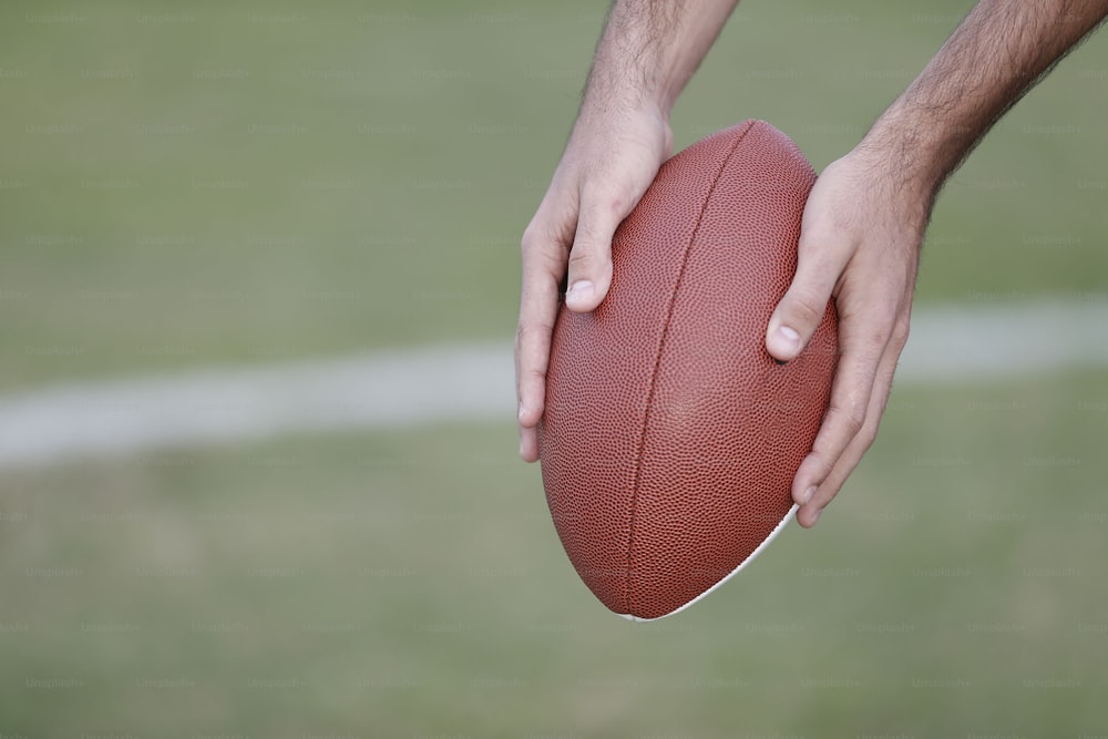 a close up of a person holding a football