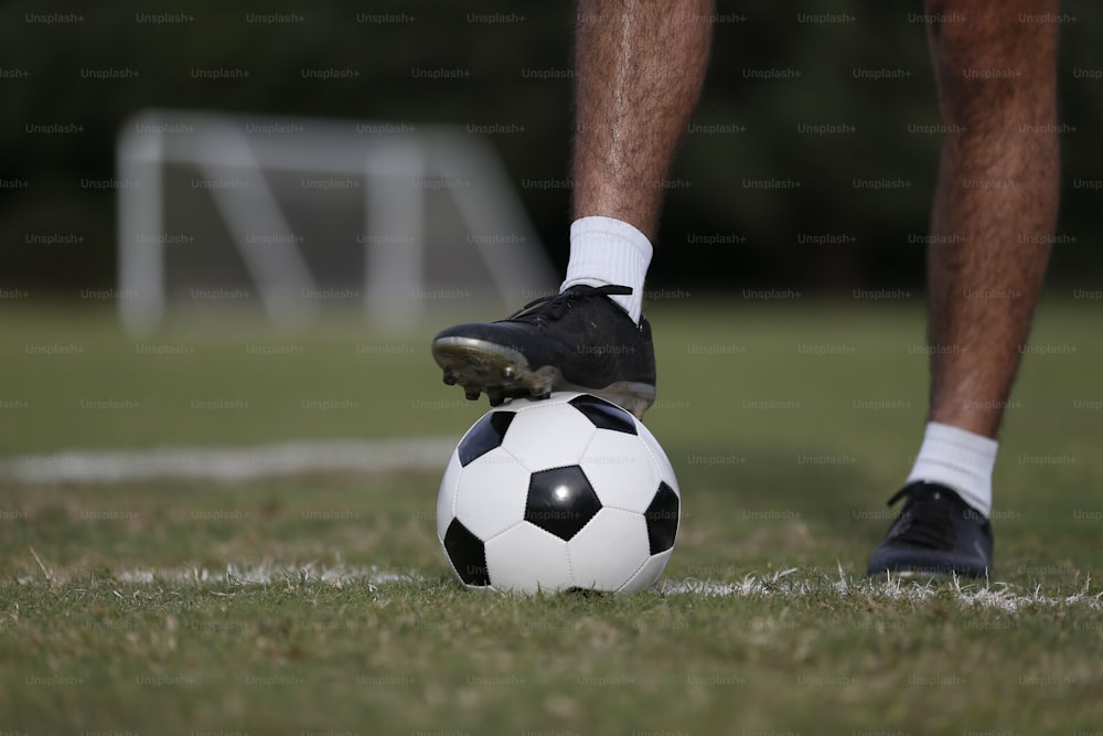 una persona in piedi sopra un pallone da calcio su un campo