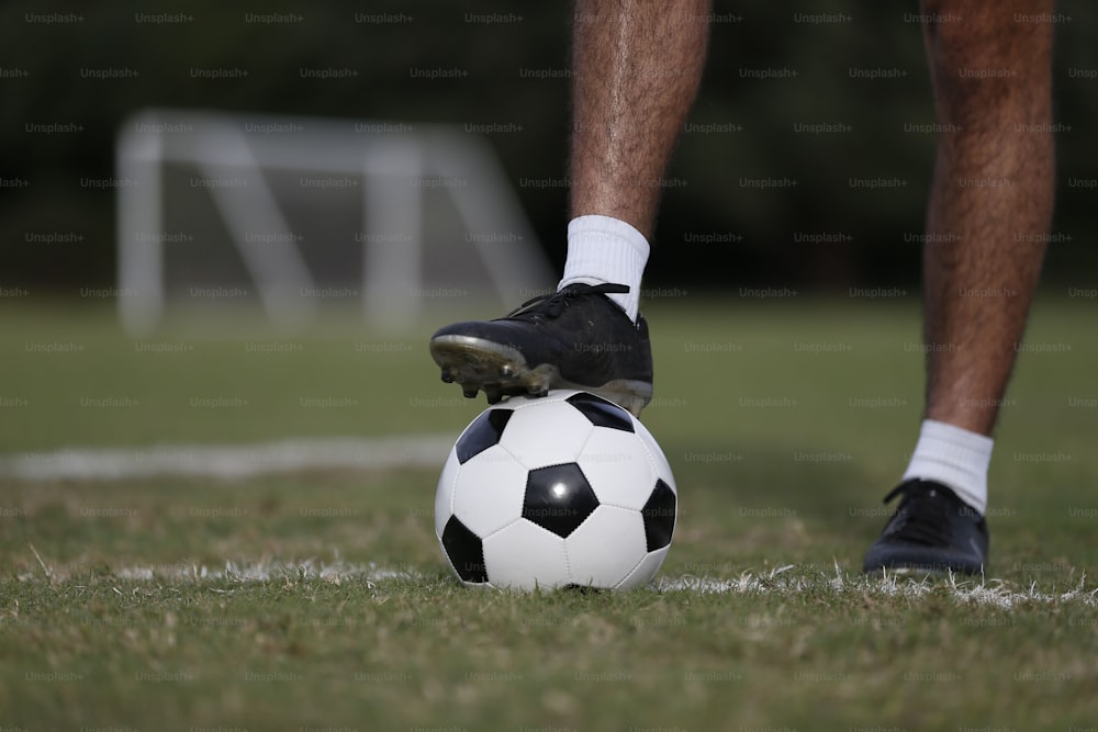 a person standing on top of a soccer ball on a field