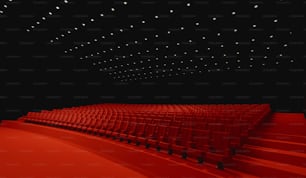 Un grand auditorium avec des rangées de sièges rouges