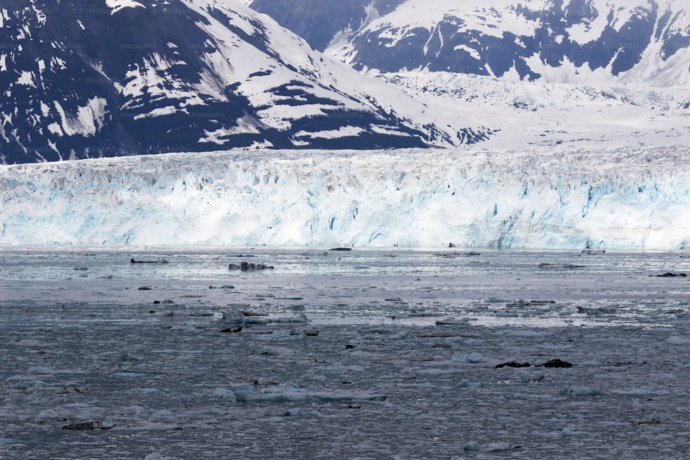 a large glacier with mountains in the background