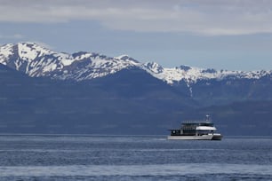a boat in a large body of water with mountains in the background