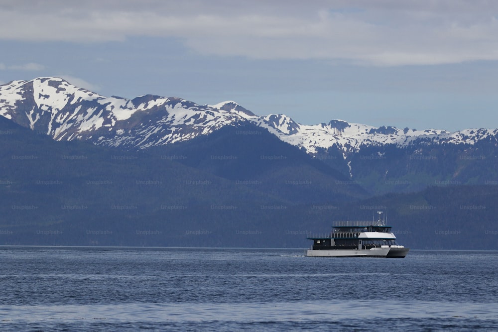 a boat in a large body of water with mountains in the background
