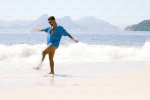 um homem em pé em uma praia ao lado do oceano